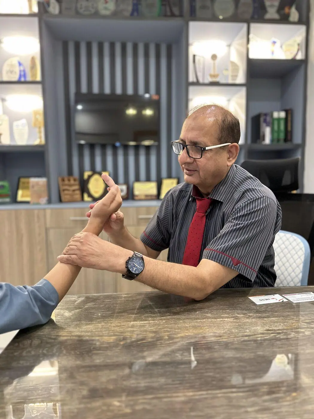 A clinician examining a patient's hand during a consultation