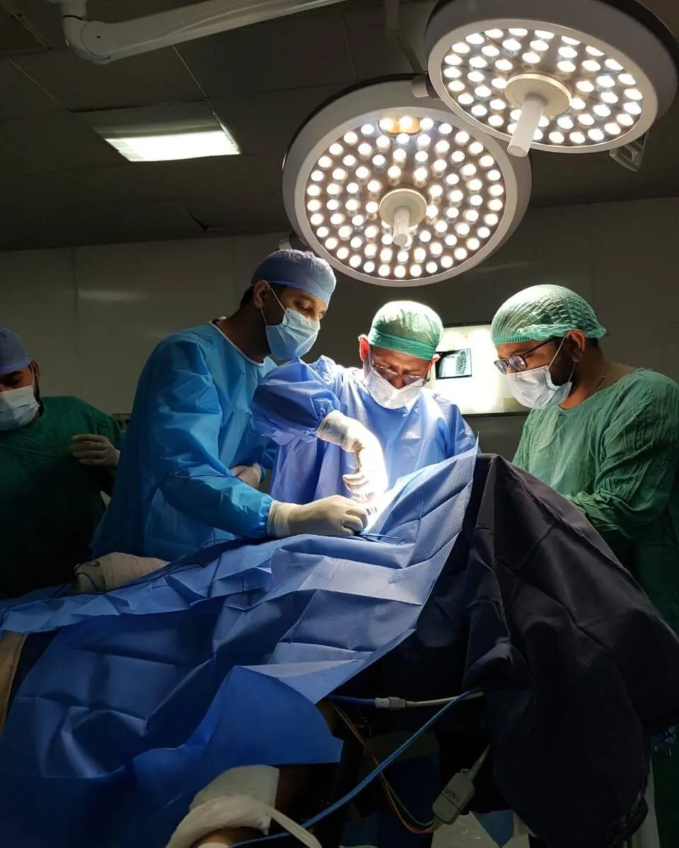 A surgical team at work beneath theatre lights